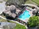 Aerial view of a community pool with red umbrellas and surrounding greenery at 25962 High Hampton Cir, Sorrento, FL 32776