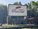 Elegant community sign featuring stone base, vibrant flowers, and the community name 'Red Tail' at 25962 High Hampton Cir, Sorrento, FL 32776