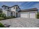 Contemporary two-story home with white exterior, two-car garage, dark trim, and a spacious, patterned brick driveway at 25962 High Hampton Cir, Sorrento, FL 32776