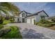 Beautiful two-story home showcasing a well-manicured lawn, palm trees, and a spacious three-car garage with a stone driveway at 25962 High Hampton Cir, Sorrento, FL 32776
