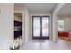 Inviting foyer with double doors, light wood flooring, and views into the kitchen and living areas at 25962 High Hampton Cir, Sorrento, FL 32776