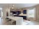 Open kitchen with a spacious island, dark cabinets, stainless appliances, and modern lighting at 25962 High Hampton Cir, Sorrento, FL 32776