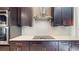 Open kitchen with dark wood cabinets, quartz countertops, stainless steel appliances, and an island with a sink at 25962 High Hampton Cir, Sorrento, FL 32776