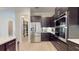Modern kitchen with stainless steel appliances, dark cabinets, and walk-in pantry at 25962 High Hampton Cir, Sorrento, FL 32776