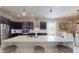 Modern kitchen features dark wood cabinets, quartz countertops, stainless steel appliances, and a large island with bar stools at 25962 High Hampton Cir, Sorrento, FL 32776