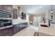 Modern kitchen features dark wood cabinets, quartz countertops, stainless steel appliances, and an island with seating at 25962 High Hampton Cir, Sorrento, FL 32776