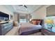 Main bedroom with a tray ceiling, modern furniture, and large windows at 25962 High Hampton Cir, Sorrento, FL 32776