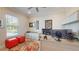 Cozy home office with a large window, a modern desk setup, and orange ottomans, offering a comfortable workspace at 25962 High Hampton Cir, Sorrento, FL 32776