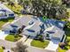 Aerial view of home showcasing well-maintained landscaping, a two-car garage, and a serene setting at 26032 Newcombe Cir, Leesburg, FL 34748