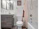 A bathroom featuring a wooden vanity, toilet, and a shower/tub with white tiles and printed curtain at 26032 Newcombe Cir, Leesburg, FL 34748