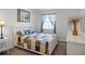 Well-lit bedroom with a patchwork quilt, a window with curtains, and a neutral color scheme at 26032 Newcombe Cir, Leesburg, FL 34748