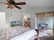 Cozy bedroom with a ceiling fan, leading to a screened lanai with outdoor seating at 26032 Newcombe Cir, Leesburg, FL 34748