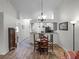 Open concept living room and kitchen layout with wood floors, a chandelier, and modern lighting fixtures at 26032 Newcombe Cir, Leesburg, FL 34748