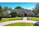 Charming brick home with manicured lawn, mature trees, and long driveway entrance at 2756 Sequoyah Dr, Haines City, FL 33844