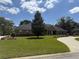 Well maintained lawn, flowerbeds, and mature landscaping surround the brick home in this picturesque outdoor shot at 2756 Sequoyah Dr, Haines City, FL 33844