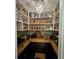 Walk-in pantry featuring a chandelier and organized shelving with decorative baskets, countertops, and tile backsplash at 2756 Sequoyah Dr, Haines City, FL 33844