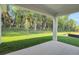 Covered back porch overlooking a spacious backyard with lush greenery and mature trees at 2980 Supermarine Rd, Tavares, FL 32778