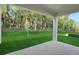 Covered back porch overlooking a spacious backyard with lush greenery and mature trees at 2980 Supermarine Rd, Tavares, FL 32778