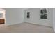 Bright bedroom with two windows and carpet flooring, next to an ensuite bathroom at 2980 Supermarine Rd, Tavares, FL 32778