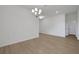 A minimalist dining room with wood floors, a modern chandelier, and ample space for entertaining at 2980 Supermarine Rd, Tavares, FL 32778