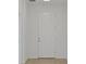 Bright, neutral entrance with white walls, white door, and wood flooring at 2980 Supermarine Rd, Tavares, FL 32778