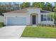 Charming single-story home with well-manicured lawn, attached garage, and inviting front entrance at 2980 Supermarine Rd, Tavares, FL 32778