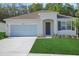 Charming single-story home with well-manicured lawn, attached garage, and inviting front entrance at 2980 Supermarine Rd, Tavares, FL 32778