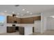 Modern kitchen with wooden cabinets, stainless steel appliances, white backsplash, and center island with white countertop at 2980 Supermarine Rd, Tavares, FL 32778