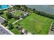 Aerial view showcasing a community recreational area featuring bocce ball courts, a sports field, and walking paths near the lake at 3048 New Haven Pl, Mount Dora, FL 32757