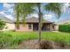 The house's backyard has a well-maintained lawn, featuring a screened-in porch and views of lush greenery at 3048 New Haven Pl, Mount Dora, FL 32757