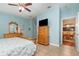 Bright bedroom with light blue walls featuring a wooden dresser and a TV on top at 3048 New Haven Pl, Mount Dora, FL 32757