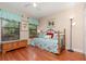 Bright bedroom with hardwood floors featuring twin windows and comfortable bedding at 3048 New Haven Pl, Mount Dora, FL 32757