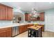 Open kitchen with stainless steel appliances, island and wood cabinetry at 3048 New Haven Pl, Mount Dora, FL 32757