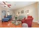 Cozy living room features hardwood floors, comfortable seating, ceiling fan, and neutral color palette at 3048 New Haven Pl, Mount Dora, FL 32757