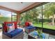 Inviting screened porch with comfortable wicker seating and plush cushions, creating an ideal space for relaxation and enjoying the outdoors at 3048 New Haven Pl, Mount Dora, FL 32757