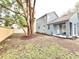 Spacious backyard featuring well-maintained lawn, mature trees, covered patio, and privacy fence at 3275 Oak Brook Ln, Eustis, FL 32736