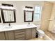 Bright bathroom featuring double sinks, granite countertops, framed mirrors, walk-in shower, and tiled floors at 3275 Oak Brook Ln, Eustis, FL 32736