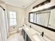 Bathroom with double vanity, granite counters, and framed mirror at 3275 Oak Brook Ln, Eustis, FL 32736