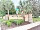 Misty Oaks community entrance sign surrounded by lush landscaping with palm trees and manicured bushes at 3275 Oak Brook Ln, Eustis, FL 32736