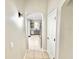 Hallway view with tile flooring, neutral paint, and arched doorway leading to the kitchen with stainless steel appliances at 3275 Oak Brook Ln, Eustis, FL 32736