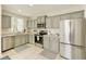 Bright kitchen with stainless steel appliances, neutral cabinets, and tile flooring at 3275 Oak Brook Ln, Eustis, FL 32736