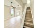 Well-lit living room featuring tile floors, staircase, archway, large windows, and a ceiling fan at 3275 Oak Brook Ln, Eustis, FL 32736