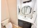 Charming powder room featuring a modern round mirror, dark vanity, white quartz countertops, and a toilet at 3275 Oak Brook Ln, Eustis, FL 32736