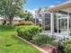 Landscaped backyard with a screened-in patio area and well-manicured lawn at 3551 Mulberry Grove Loop, Leesburg, FL 34748