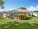 Expansive backyard with a screened-in patio, lush landscaping, and privacy at 3551 Mulberry Grove Loop, Leesburg, FL 34748