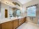 Bright bathroom featuring a double sink vanity and a glass-enclosed shower at 3551 Mulberry Grove Loop, Leesburg, FL 34748