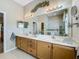 Bright bathroom featuring a double sink vanity and a glass-enclosed shower at 3551 Mulberry Grove Loop, Leesburg, FL 34748