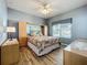Cozy bedroom with wood floors and a ceiling fan at 3551 Mulberry Grove Loop, Leesburg, FL 34748