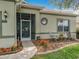 Close up of a cozy front porch with chairs and a decorative glass front door at 3551 Mulberry Grove Loop, Leesburg, FL 34748