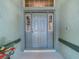 Contemporary front door with sidelights and transom window, set in a neutral color scheme at 3551 Mulberry Grove Loop, Leesburg, FL 34748